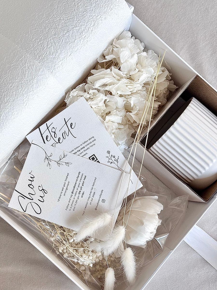 A kit open in its box with the how-to and Show Us cards resting on the stems